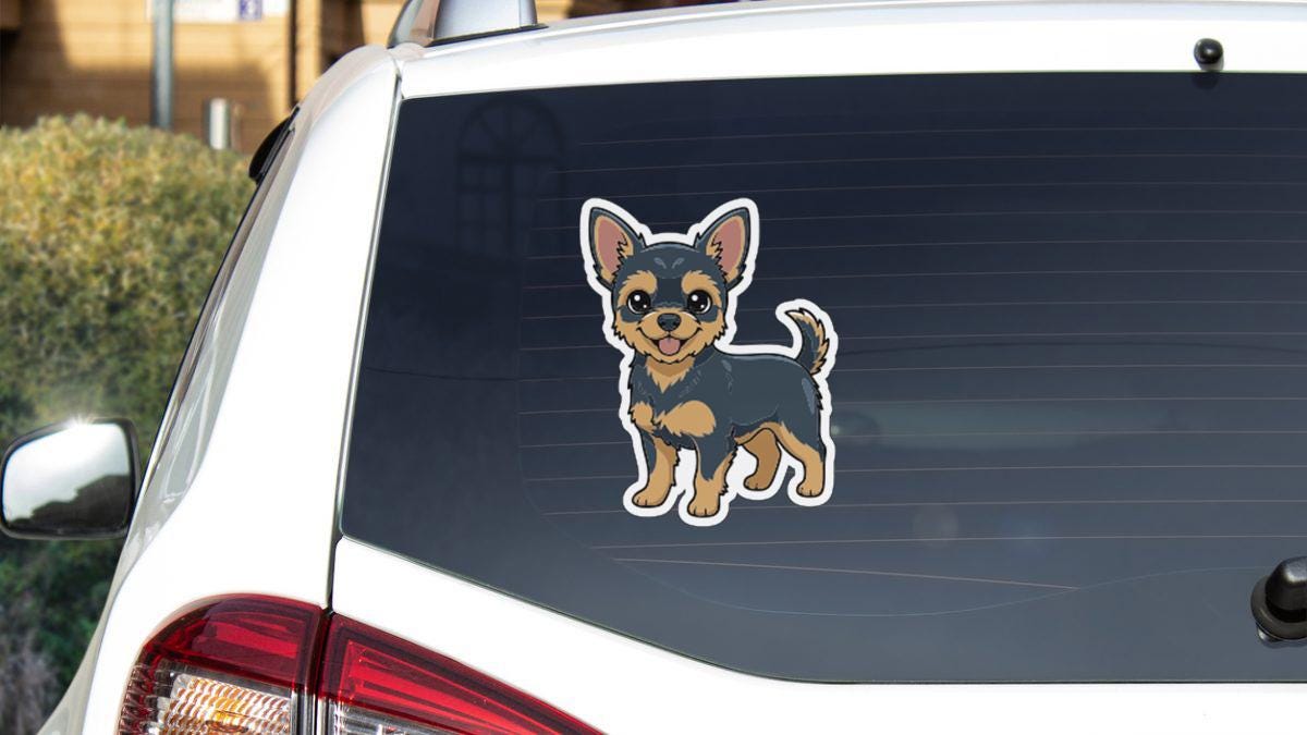 A sticker of a small dog, likely a Chihuahua, is displayed on the rear window of a white car.