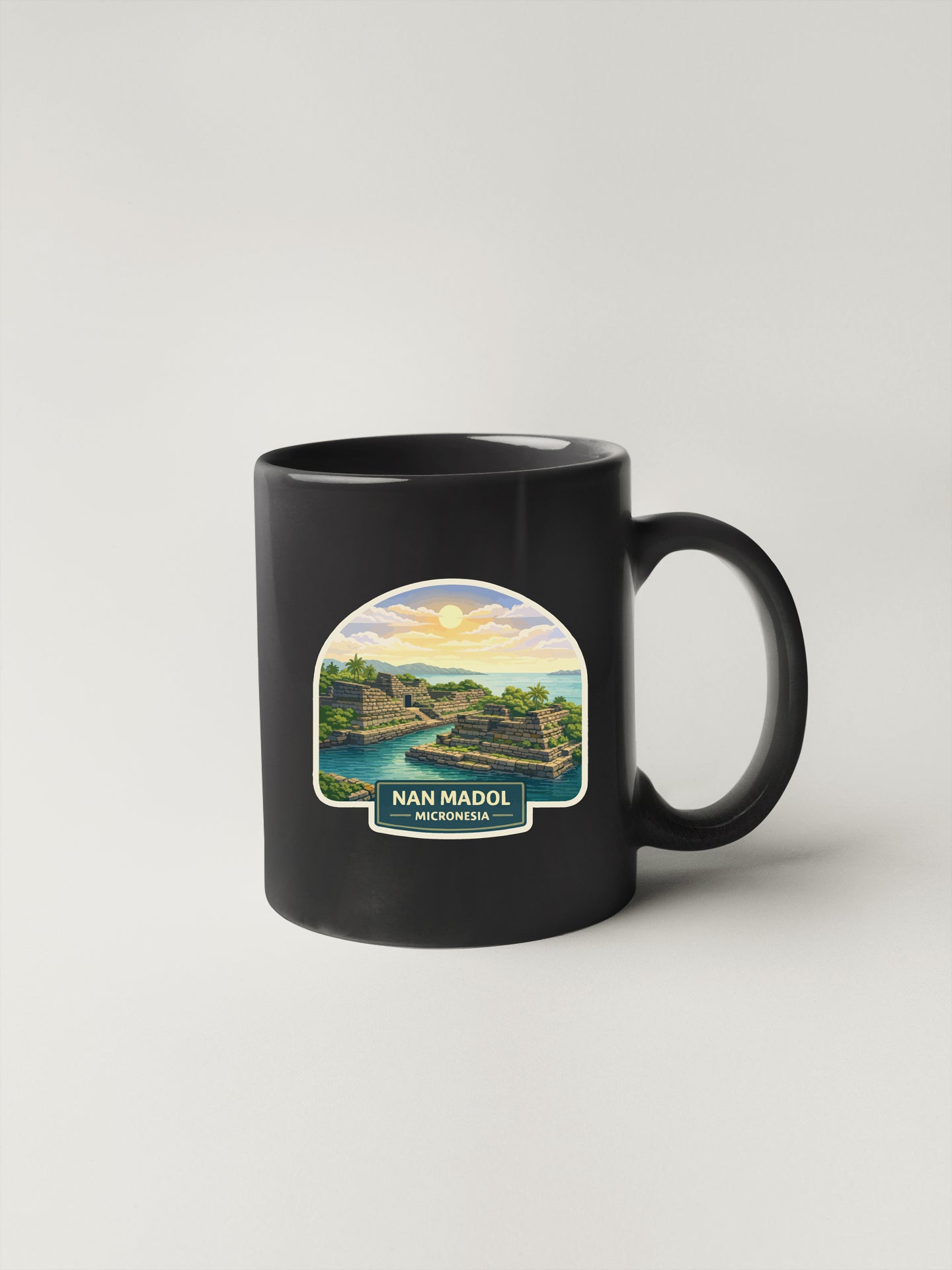 A black coffee mug with a printed image of a scenic landscape, including a body of water, mountains, and a sunset.