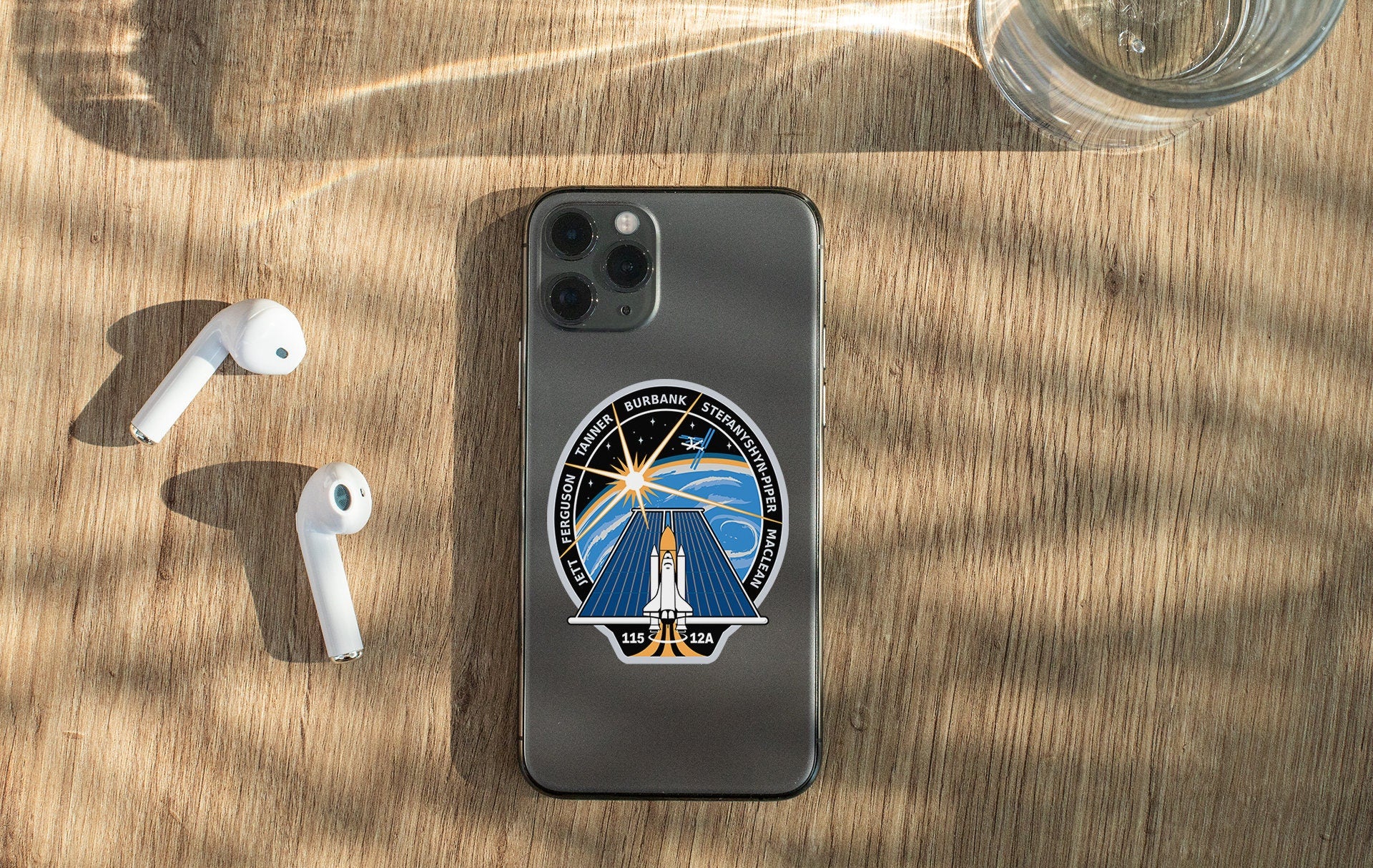 a phone with a sticker on it next to ear buds