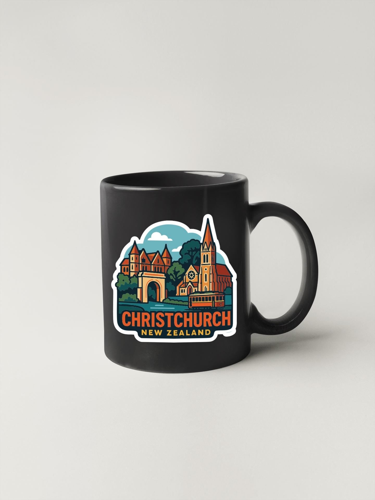 A black coffee mug with a colorful illustration of Christchurch, New Zealand, featuring a church, buildings, and a landscape.