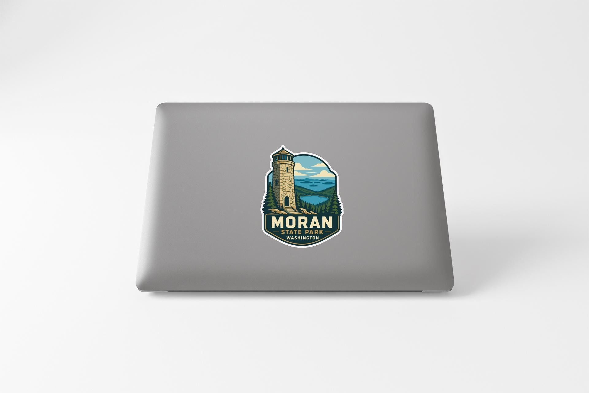 a sticker on the back of a laptop that displays a lighthouse and the text "MORAN LIGHT PORTO, WASHINGTON".