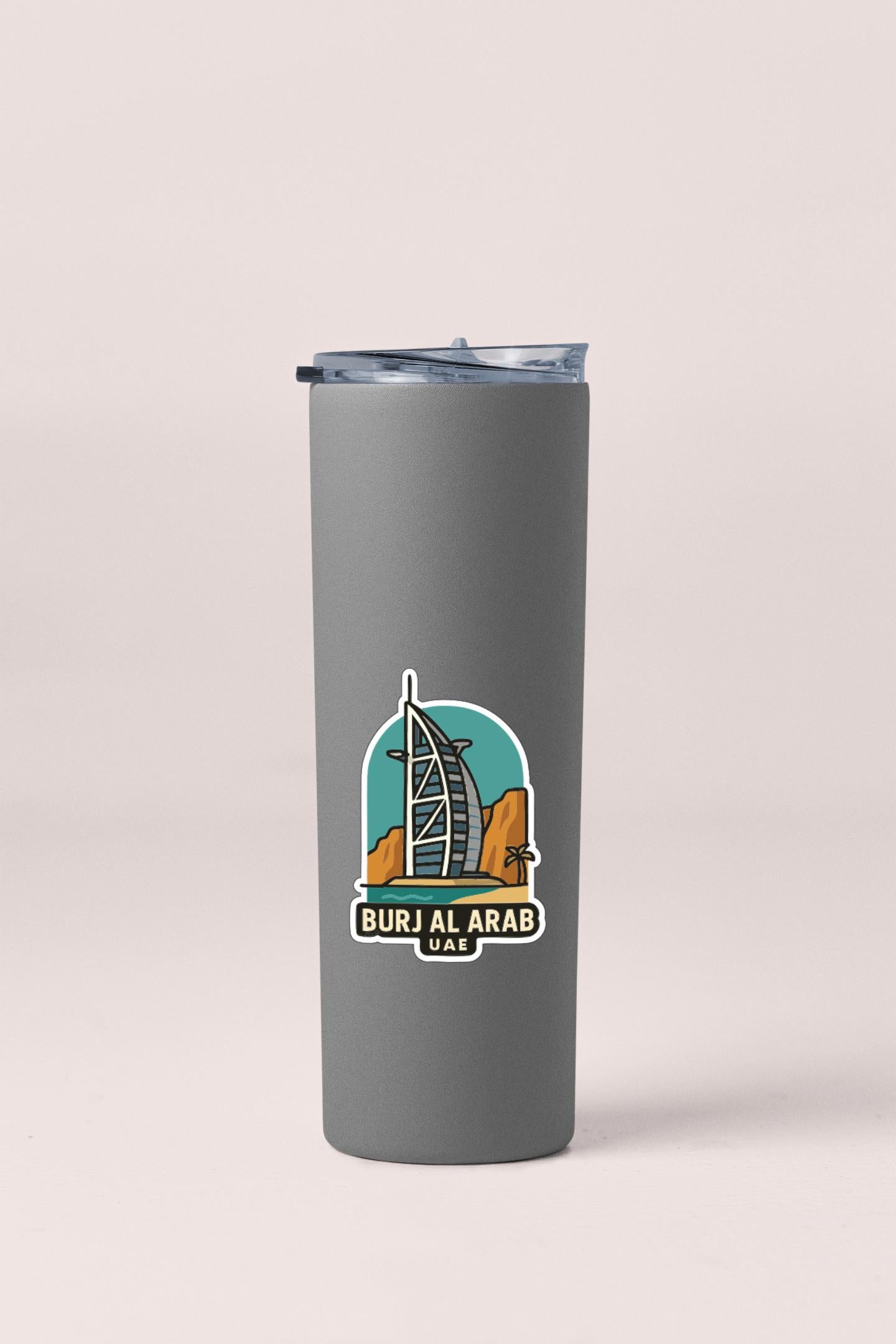 A gray insulated tumbler with a sticker depicting the Burj Al Arab hotel in Dubai.