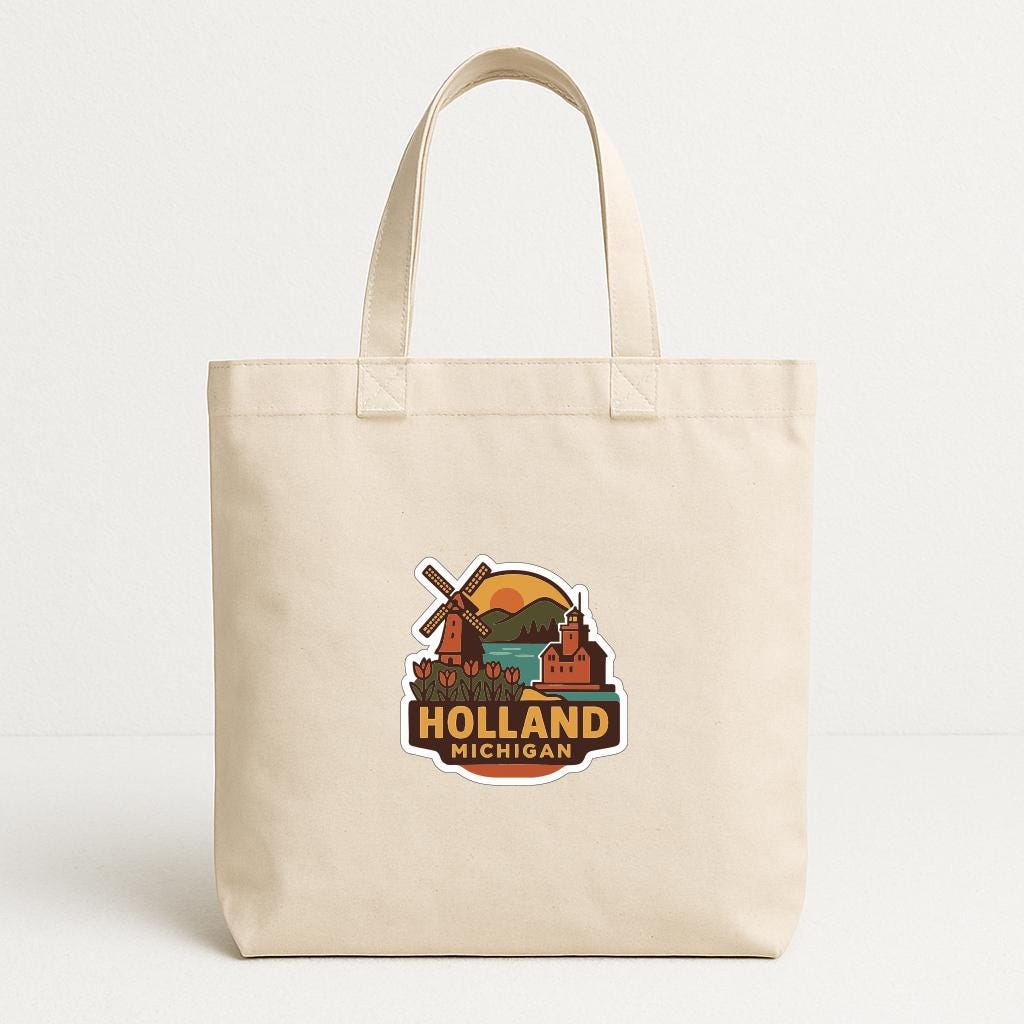 A beige tote bag with a graphic design featuring a windmill, a sunset, and the text "HOLAND MICHIGAN" printed on it.