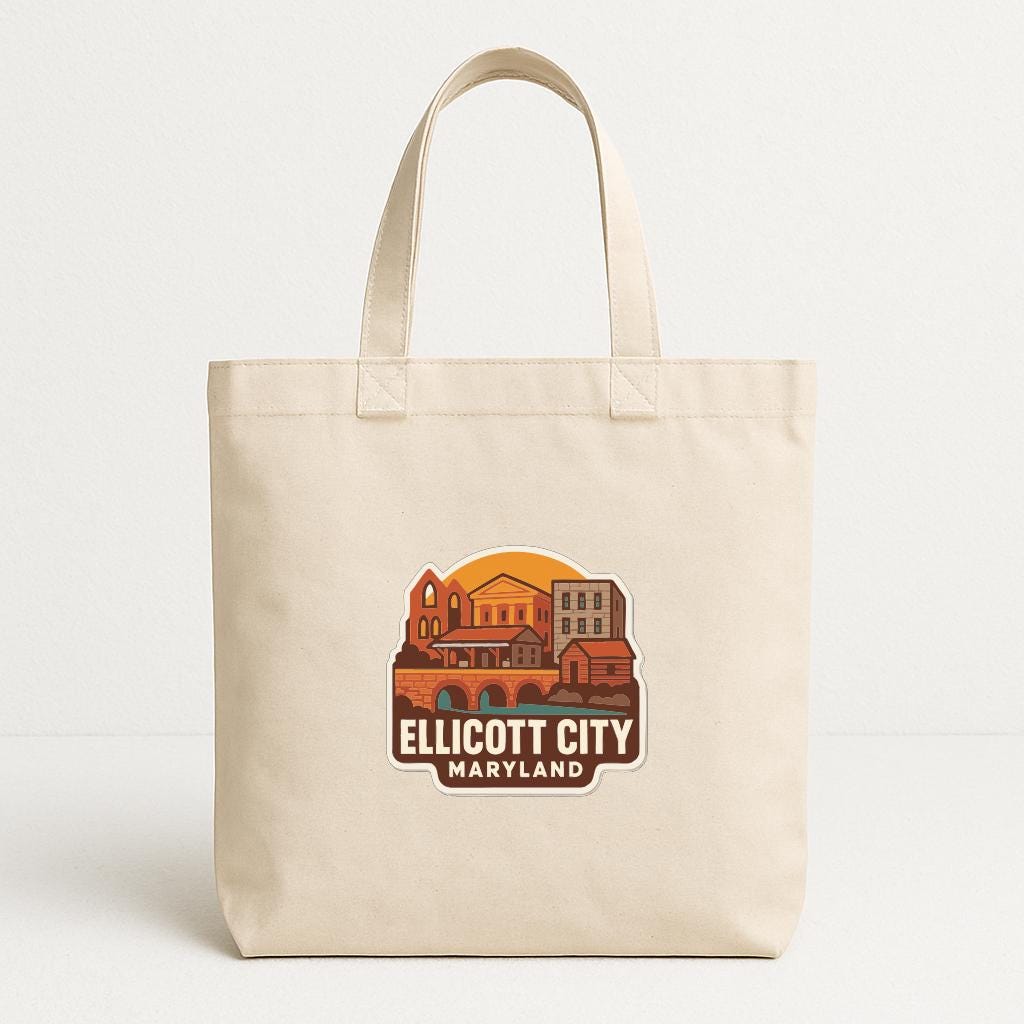 A beige tote bag with a printed design depicting a cityscape and the text "ELLICOTT CITY MARYLAND" printed on it.