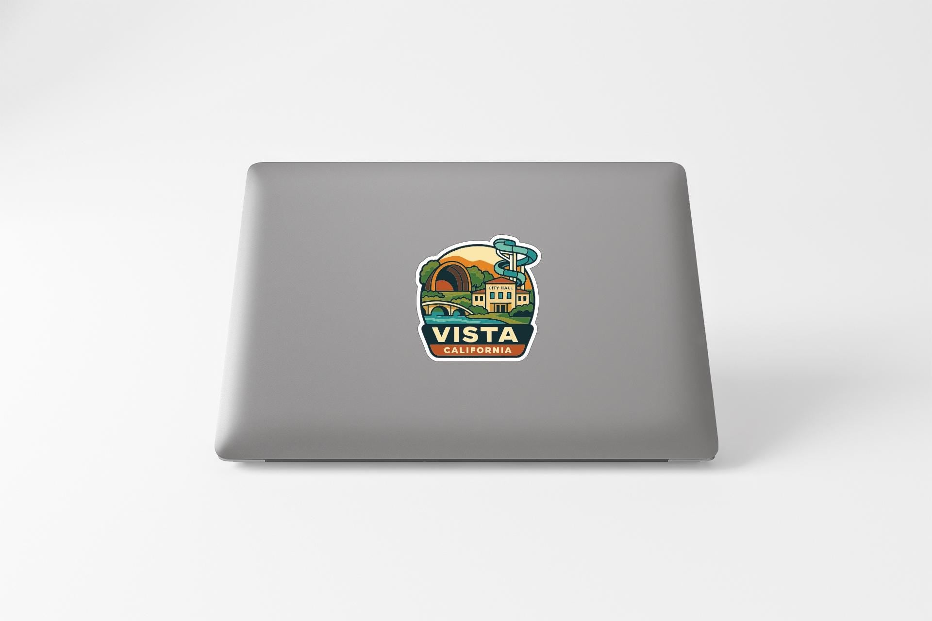 a sticker with a scenic illustration of a landscape and the text "Vista California" on a laptop.