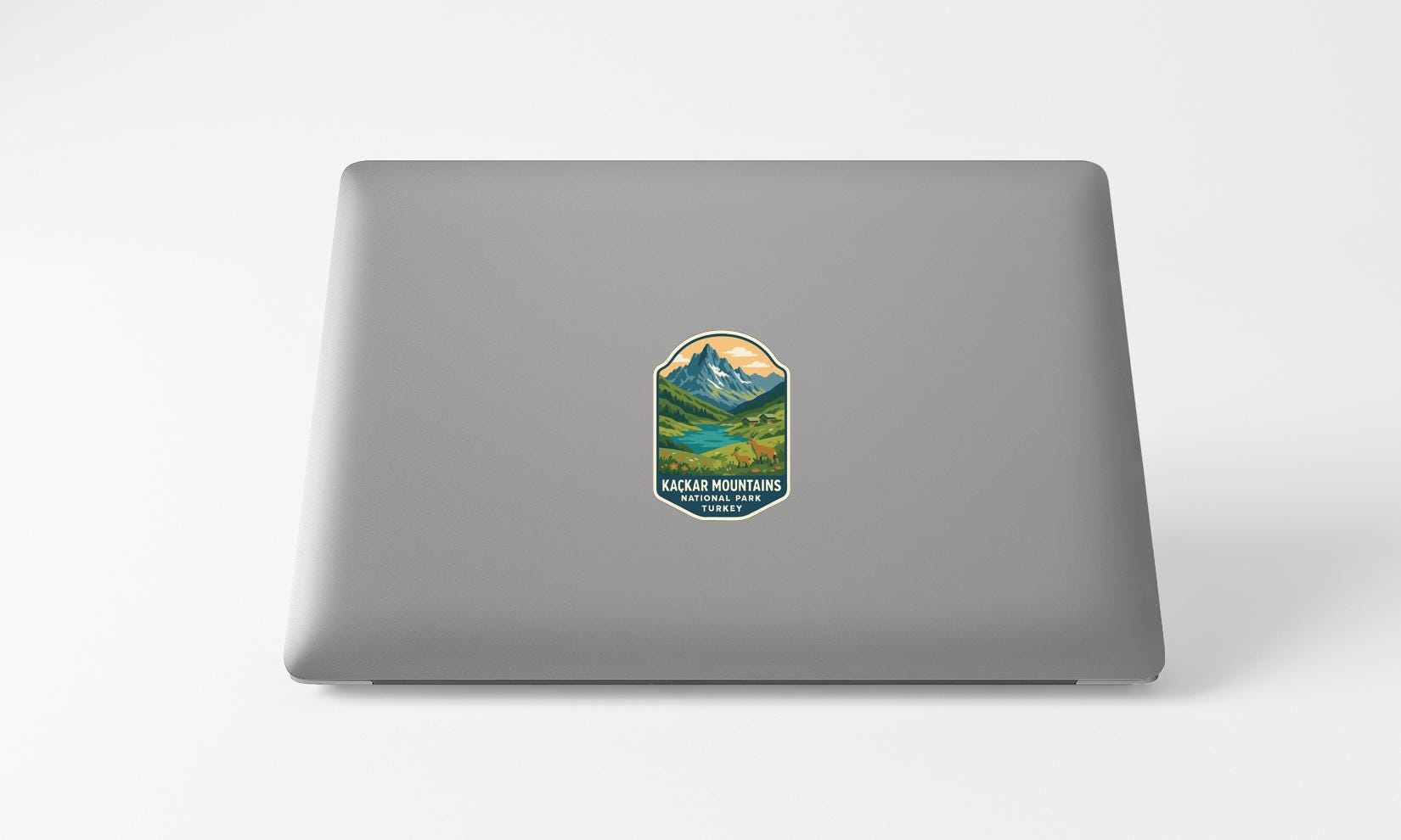 A sticker with a mountain landscape on a laptop.