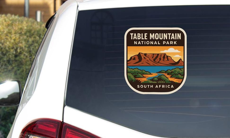 A sticker on the rear window of a car that says "TABLE MOUNTAIN NATIONAL PARK SOUTH AFRICA".