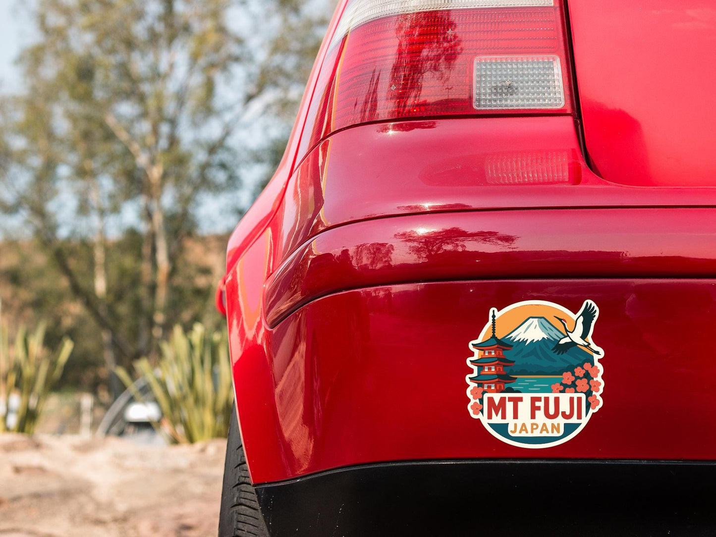 the rear end of a red car with a sticker on the trunk that says "MT FUJI JAPAN".