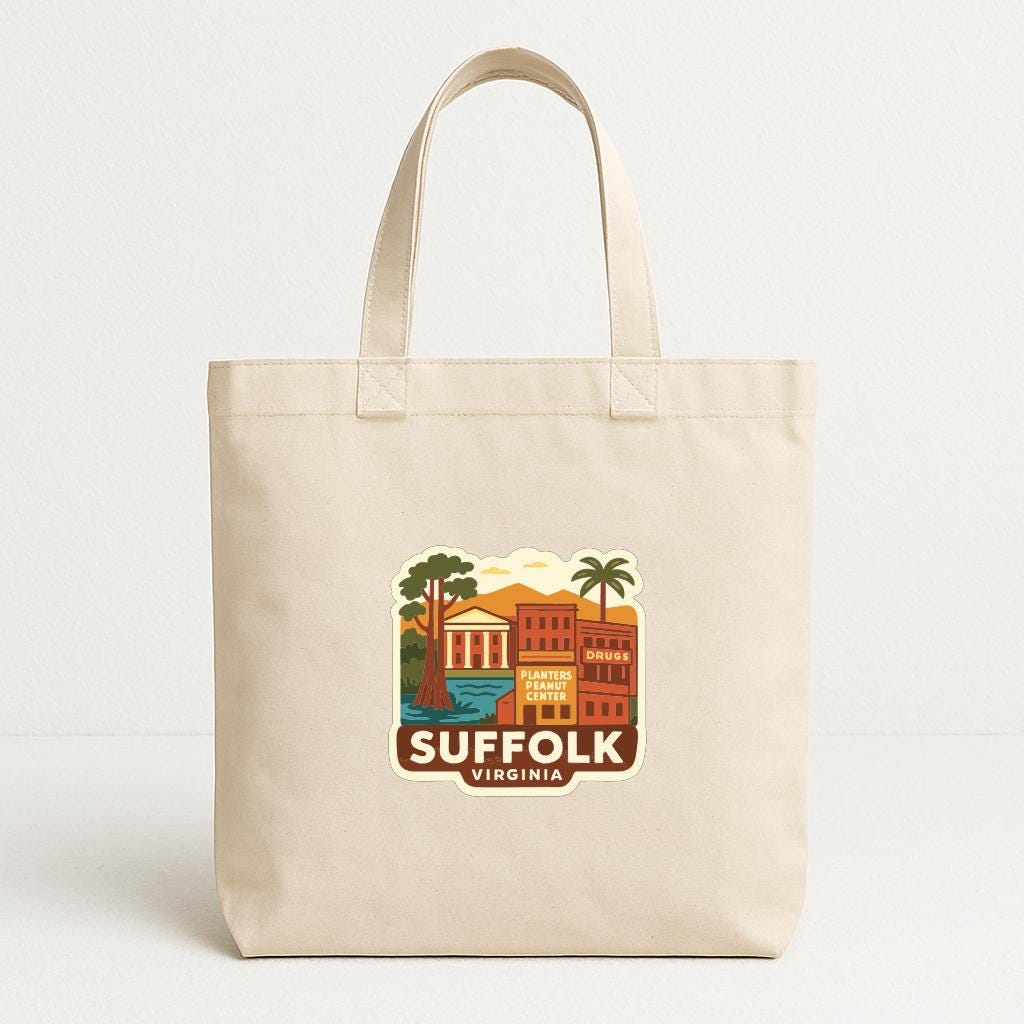 A beige tote bag with a printed design depicting a cityscape and the text "SUFFOLK VIRGINIA" printed on it.