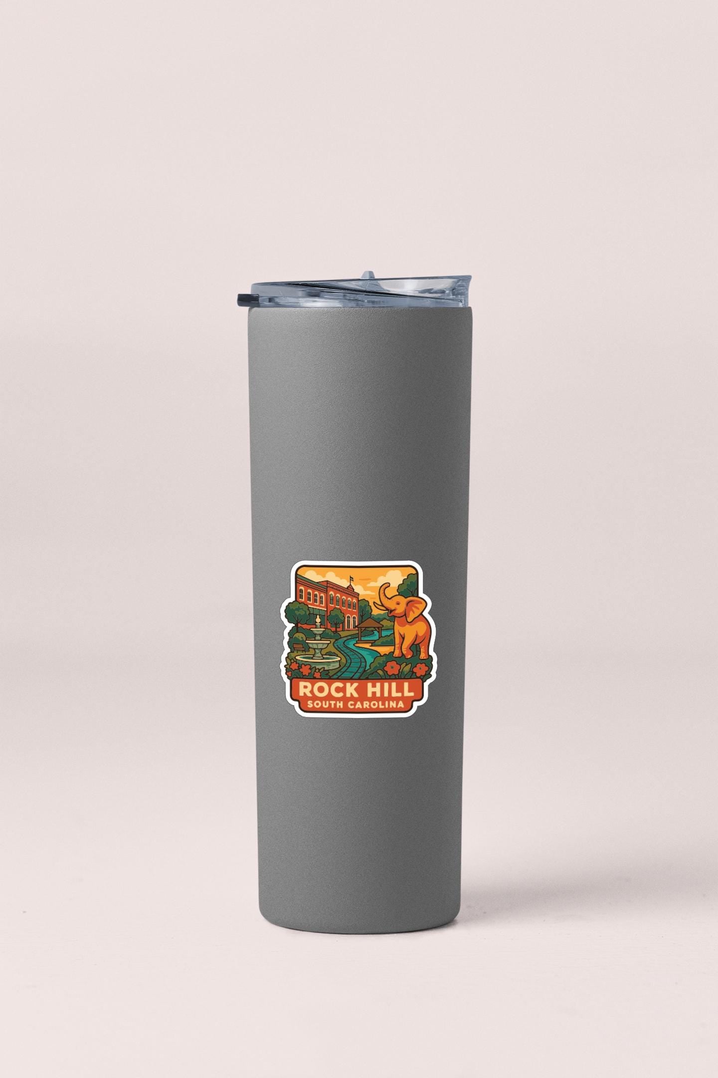 A gray insulated tumbler with a sticker on it, featuring an illustration of a building and an elephant.