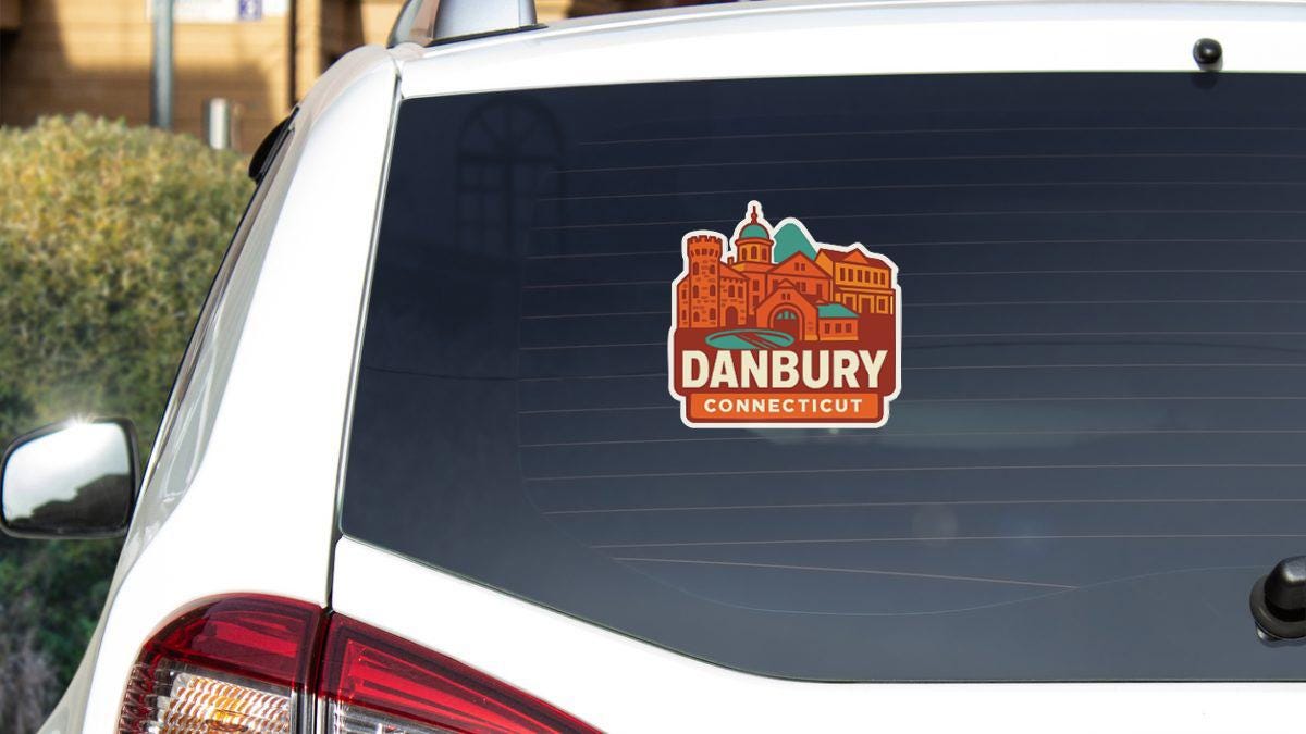 A sticker on the rear window of a white car, displaying the name "Danbury Connecticut".