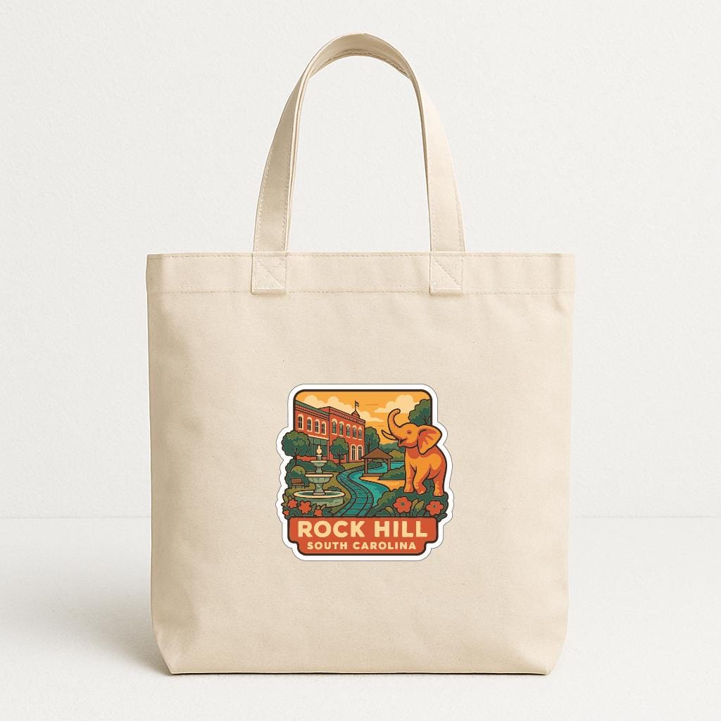 A beige tote bag with a printed design depicting a scenic view of Rock Hill, South Carolina.