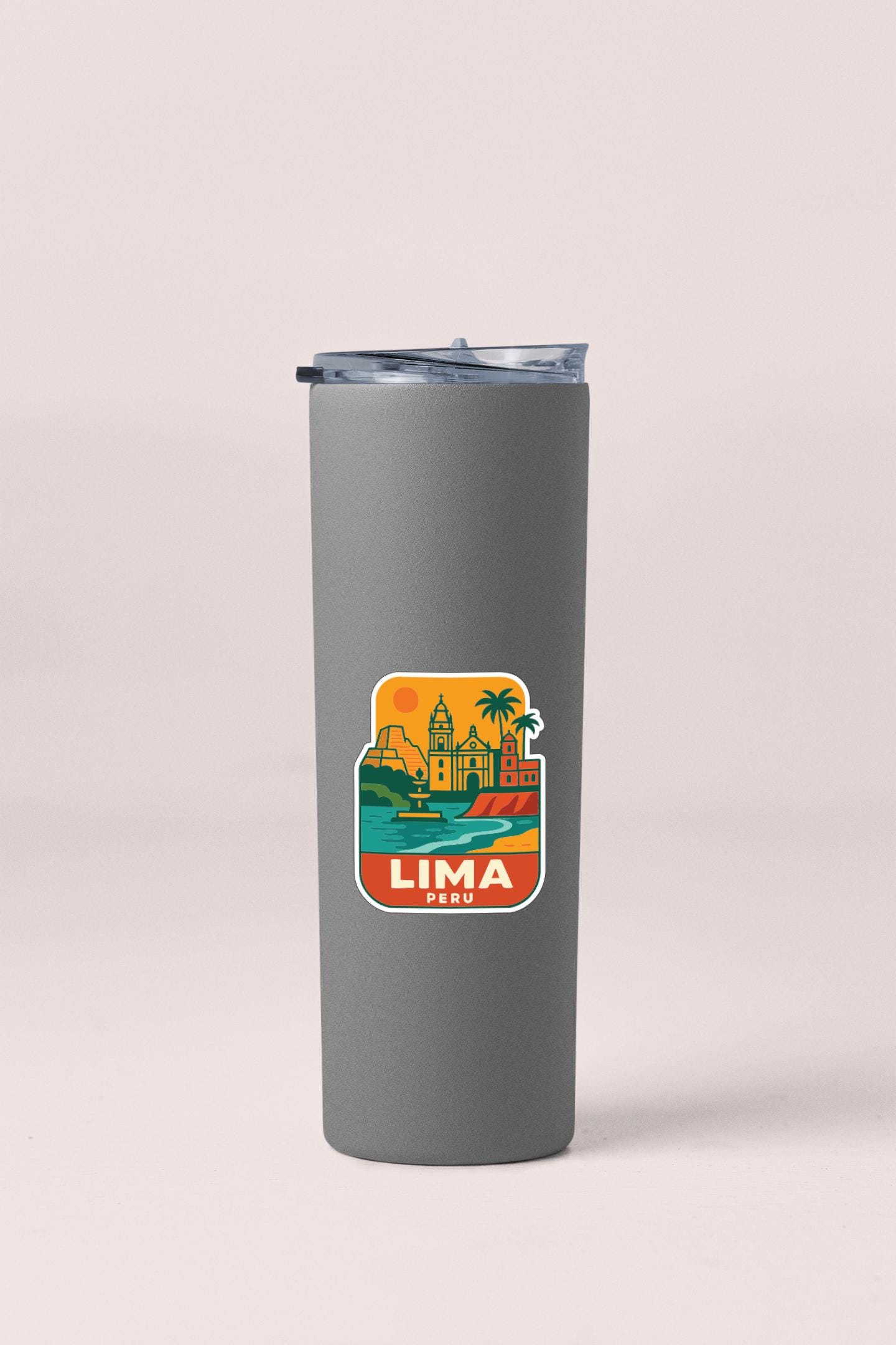 A gray insulated tumbler with a colorful sticker depicting the cityscape of Lima, Peru.