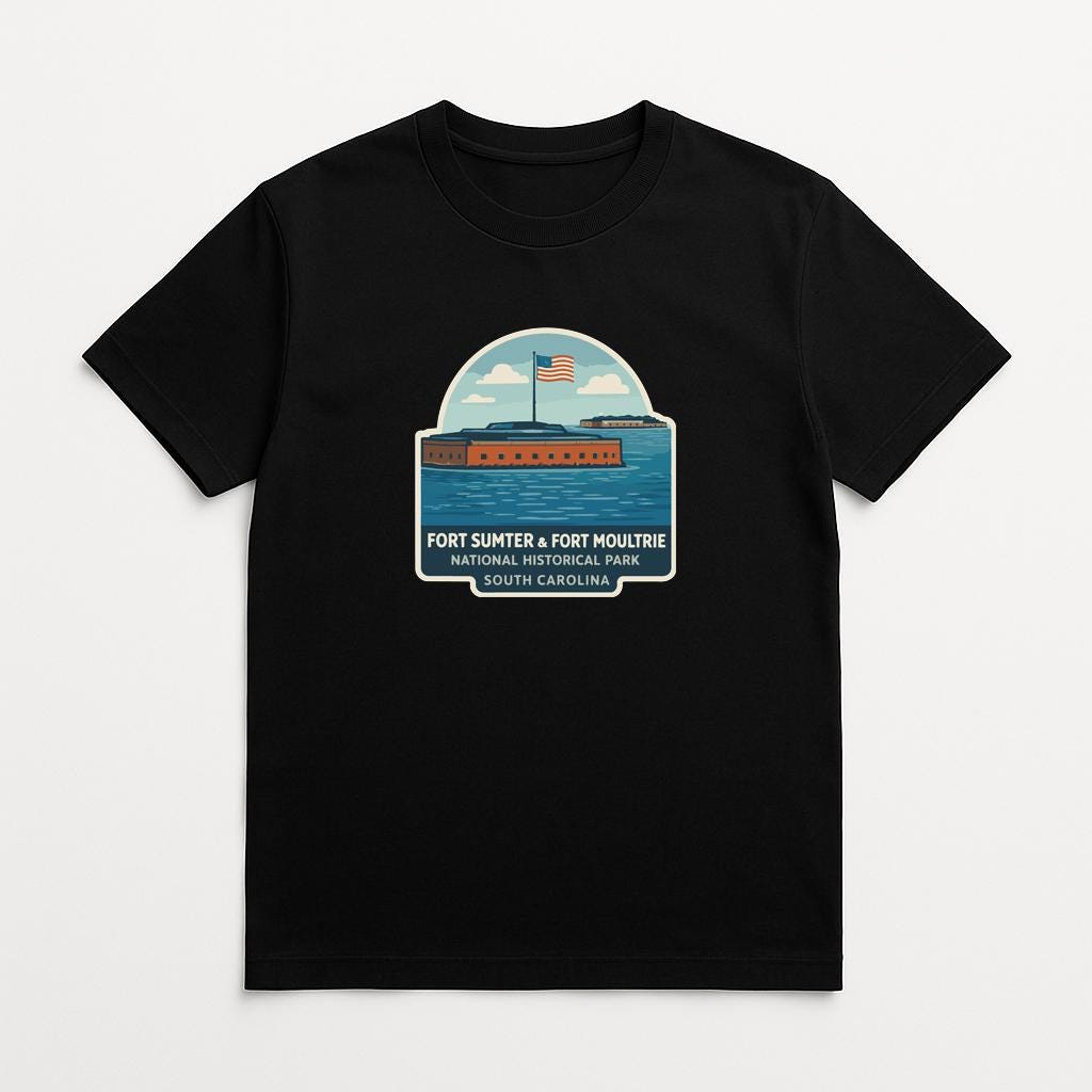 A black t-shirt with a graphic design depicting a ship sailing on a body of water, with an American flag flying above it.
