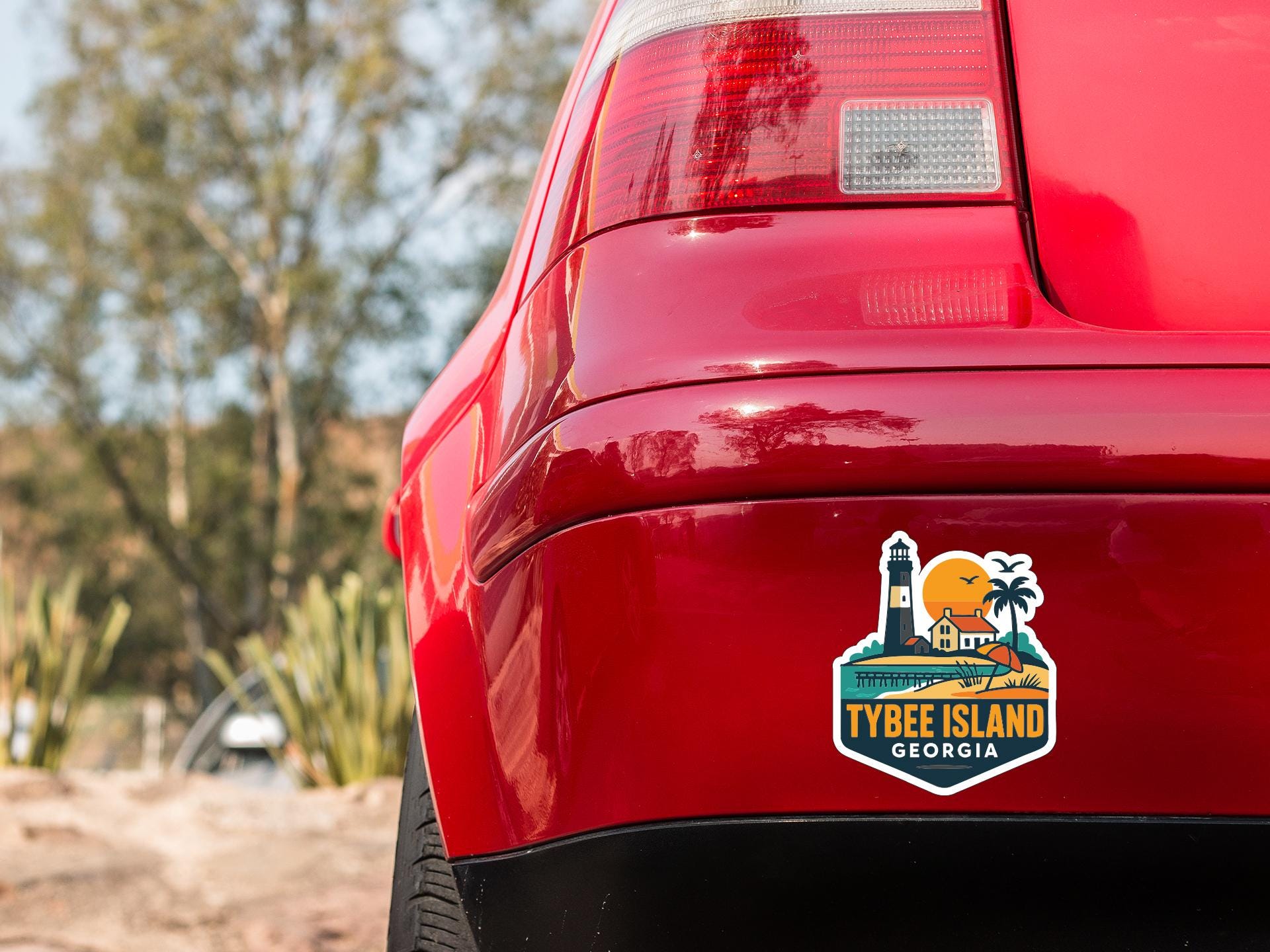 the rear end of a red car with a sticker on the trunk that says "TYBEE ISLAND GEORGIA".