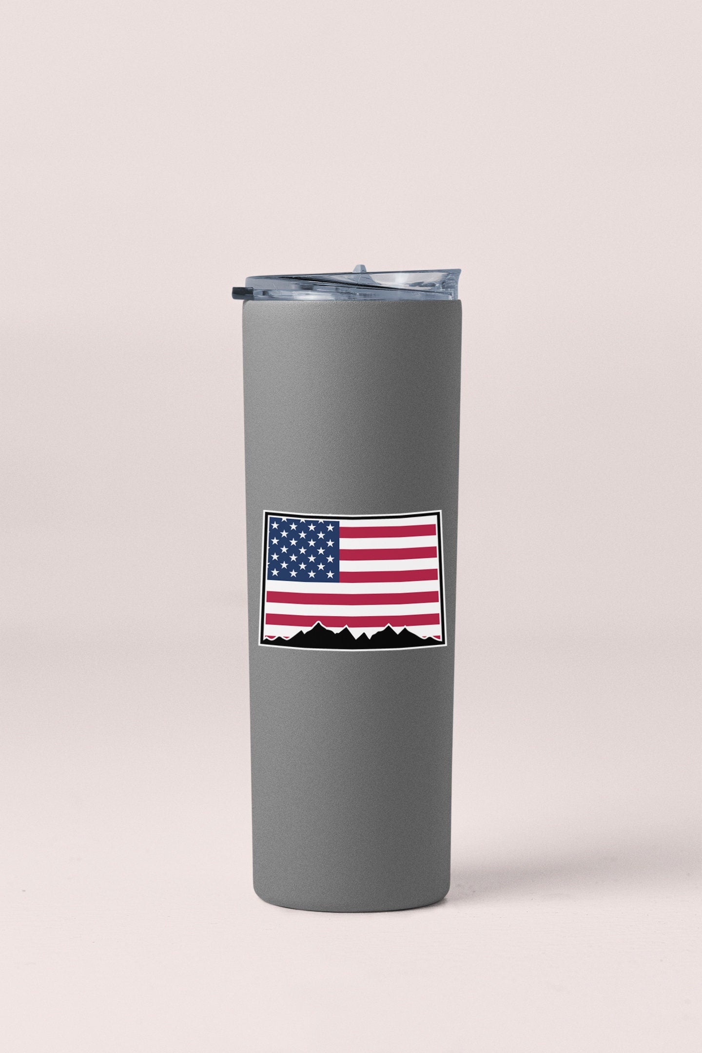 a gray tumbler with an american flag sticker on it