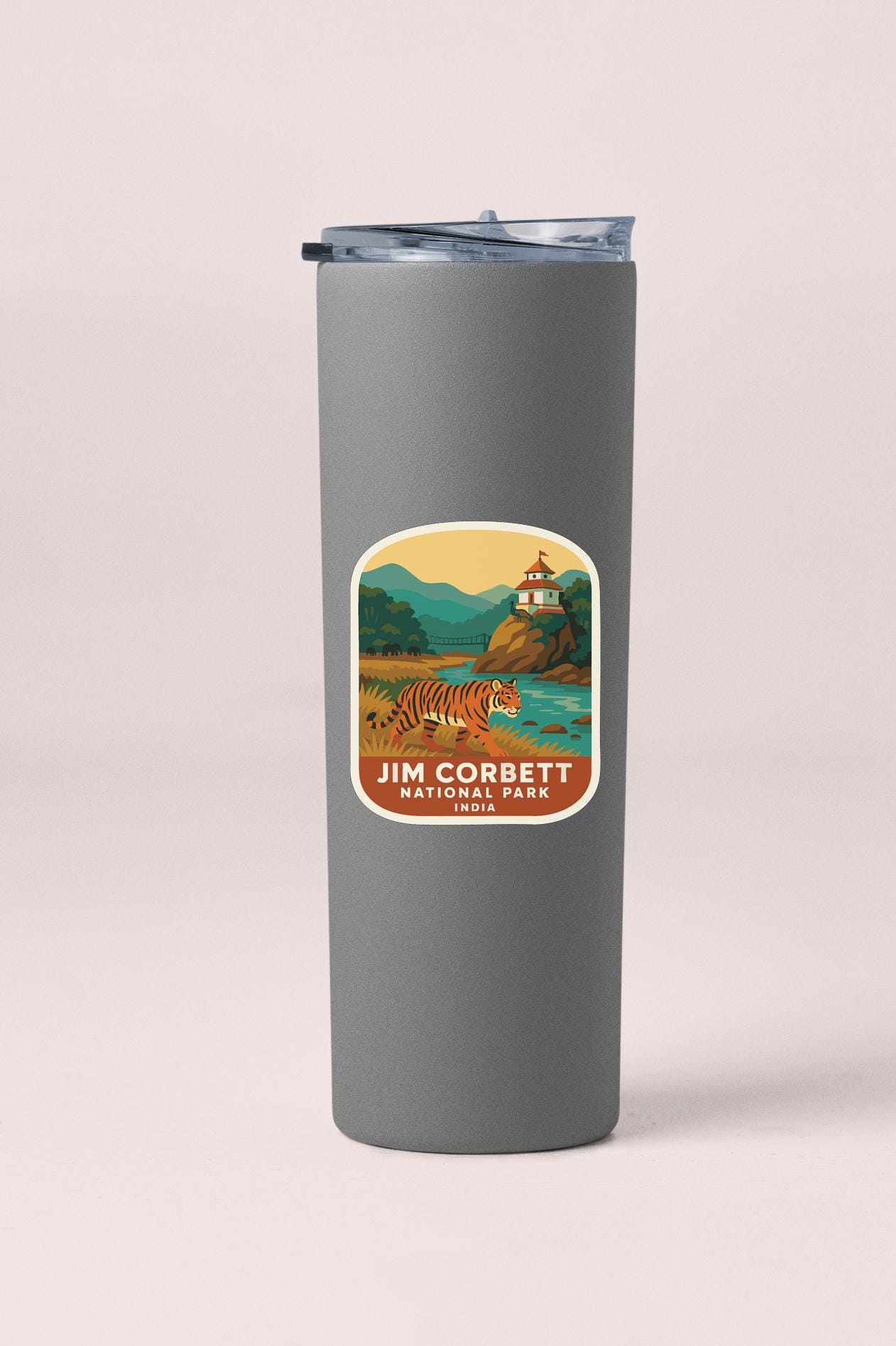 A gray insulated tumbler with a sticker depicting a tiger in a natural setting.