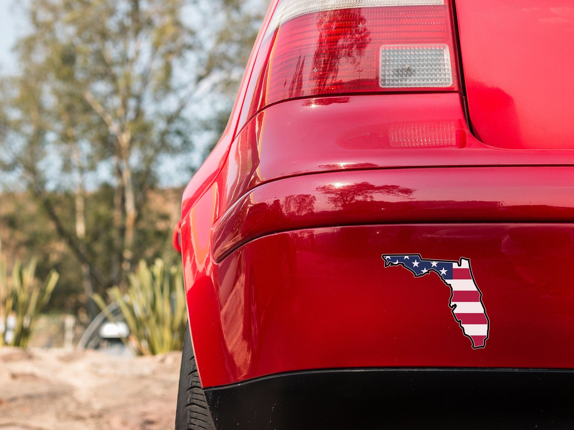 a red car with an american flag sticker on it
