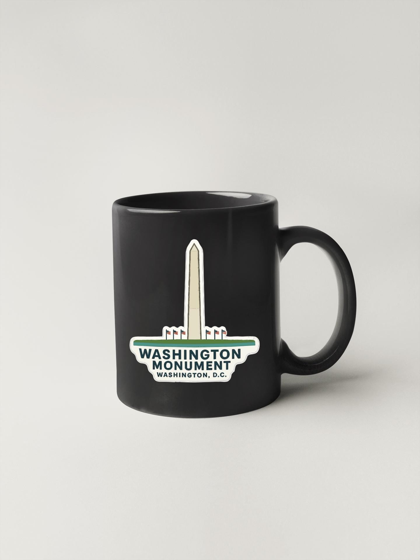 A black coffee mug with a graphic of the Washington Monument and the text "WASHINGTON MONUMENT WASHINGTON, D.C." printed on it.