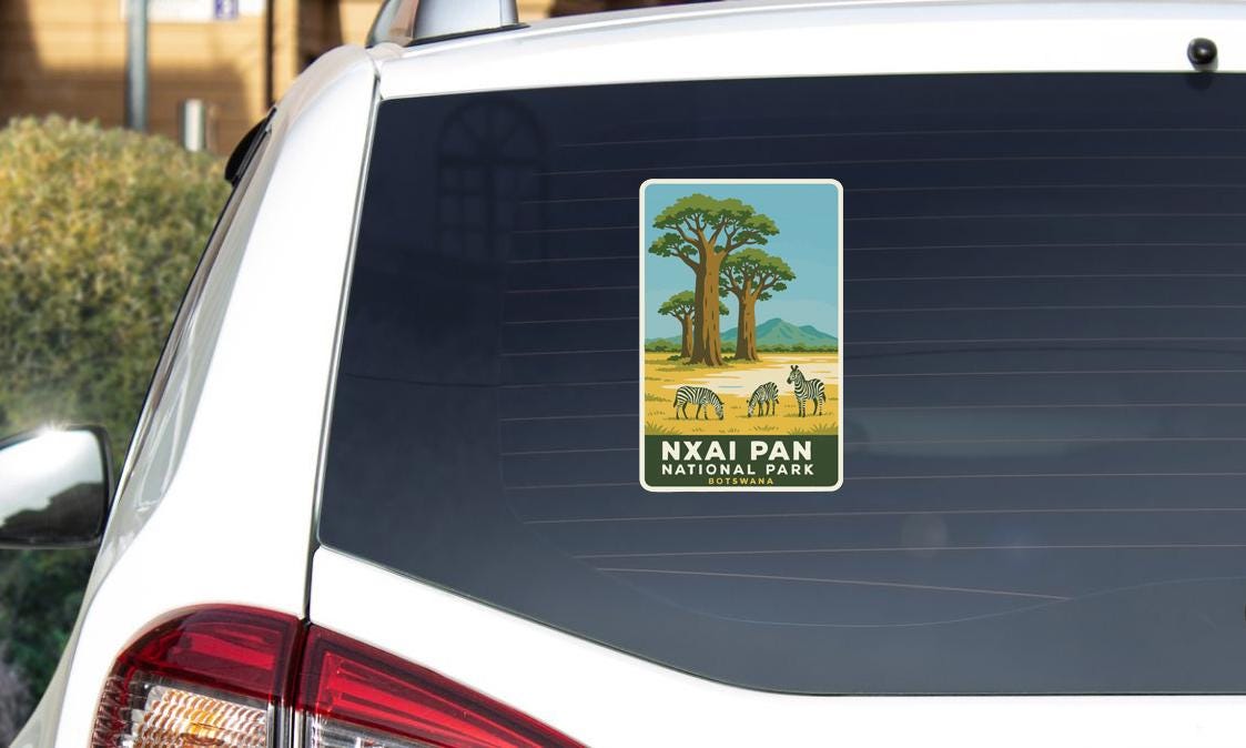 A sticker on the rear window of a car, depicting a scenic landscape with a large tree and wildlife in the background.