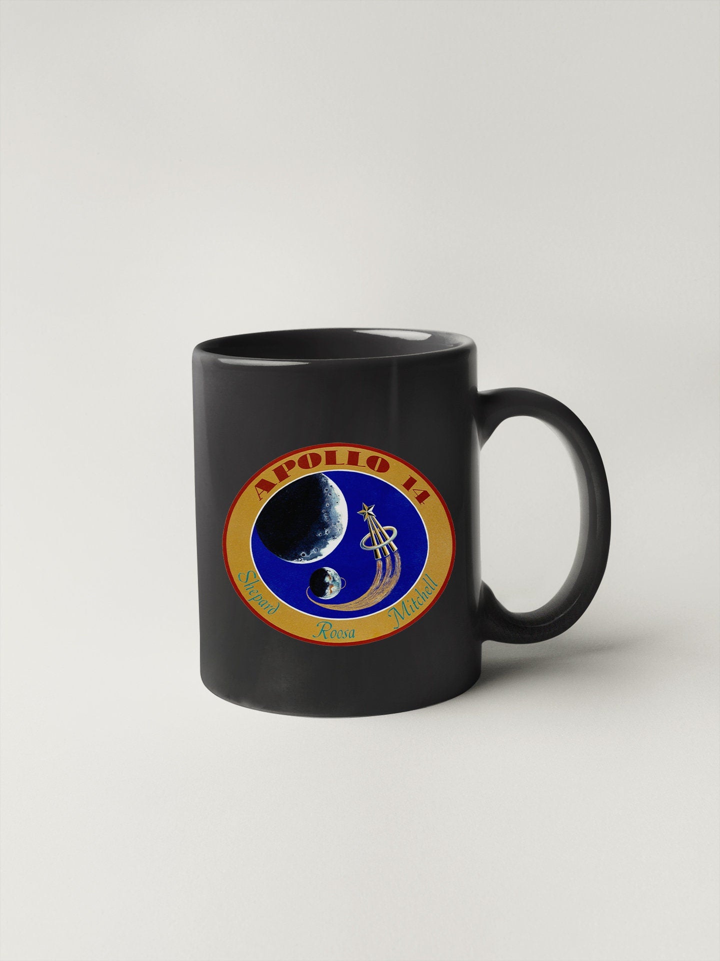 a black coffee mug with a nasa emblem on it