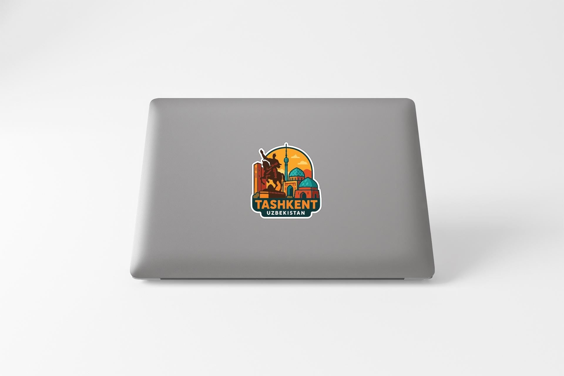 a sticker or decal on the back of a laptop, depicting a cityscape with a prominent building and the text "Tashkent Uzbekistan".
