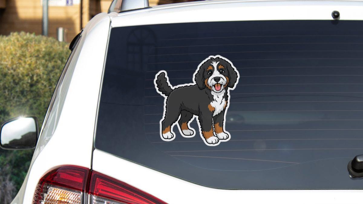 a sticker of a Bernese mountain dog on the rear window of a white car.