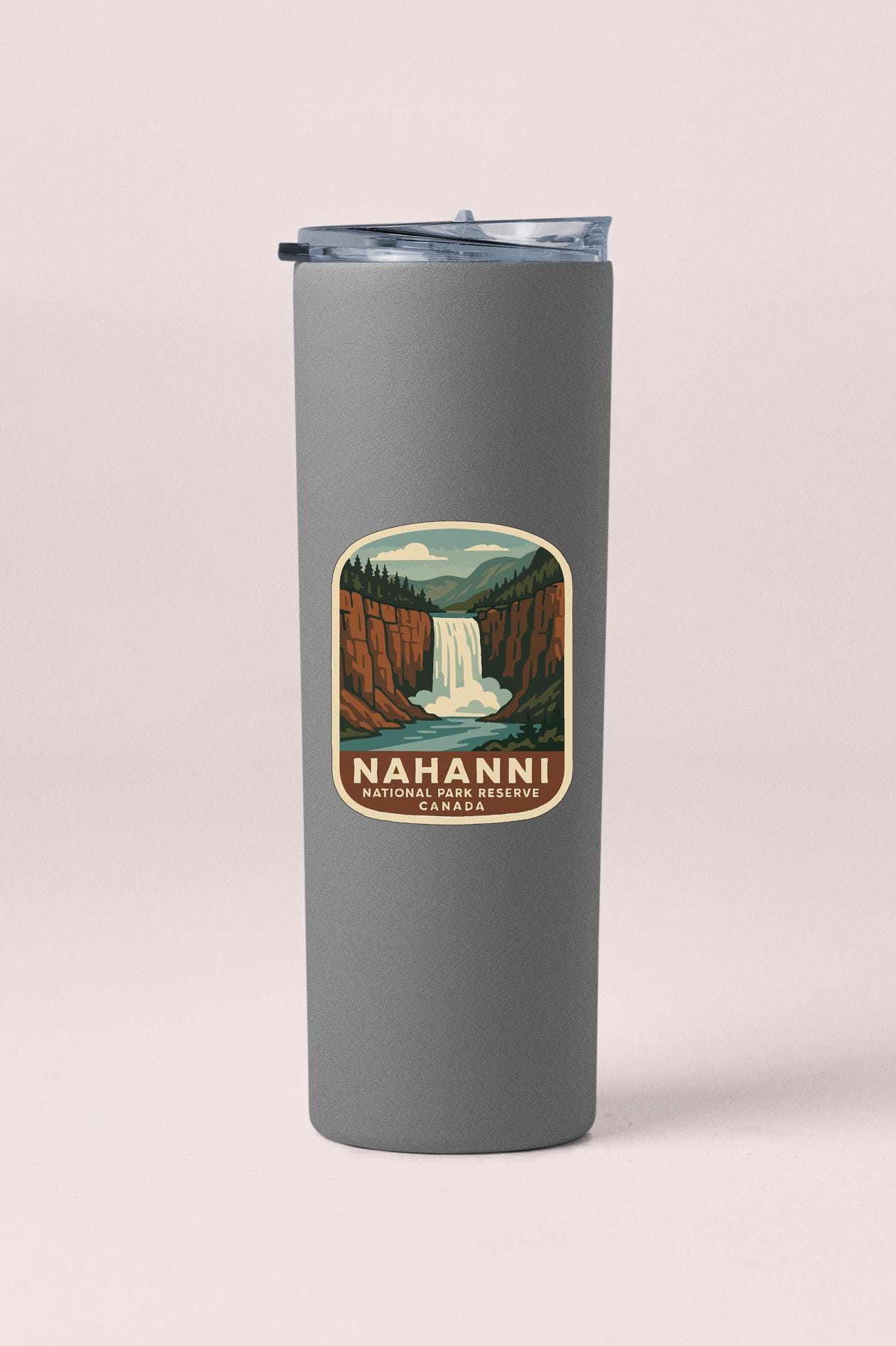 A gray insulated tumbler with a printed label depicting a waterfall and mountains, representing the location of the Niagara Falls, Canada.