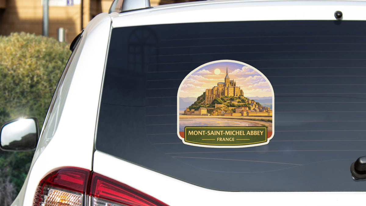 A sticker on the rear window of a car depicting the iconic Mont-Saint-Michel Abbey in France.