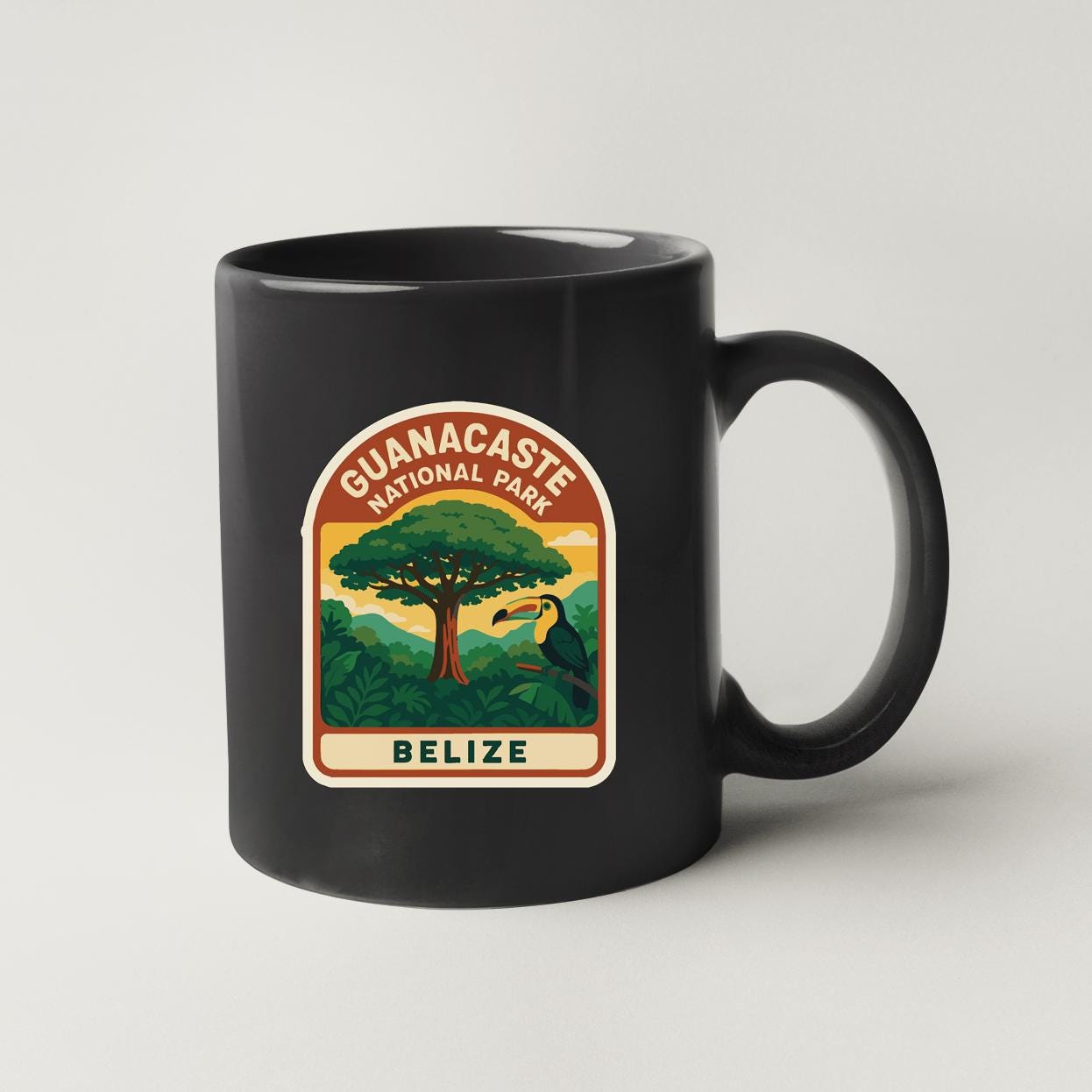 A black coffee mug with a graphic design depicting a tropical forest scene and a toucan bird.