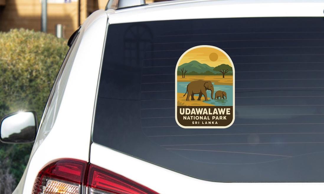 A sticker on the rear window of a car, depicting an elephant and a landscape with mountains, indicating that the car is in a national park in Sri Lanka.