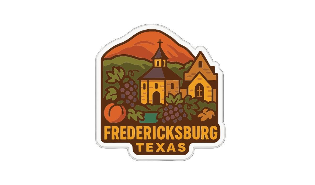 A sticker or emblem featuring a church, mountains, and various fruits and vegetables, with the text "FREDERICKSBURG TEXAS" prominently displayed.