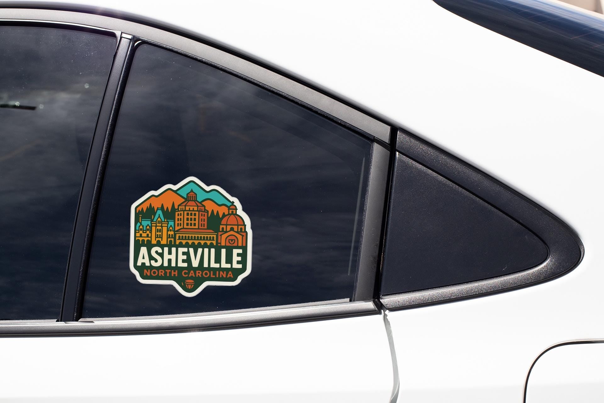 A sticker on the side of a car window that says "Asheville, North Carolina".