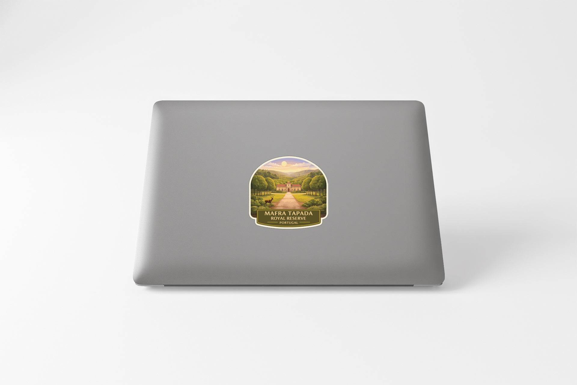 a sticker on the back of a laptop, depicting a scenic landscape with a road leading through it.