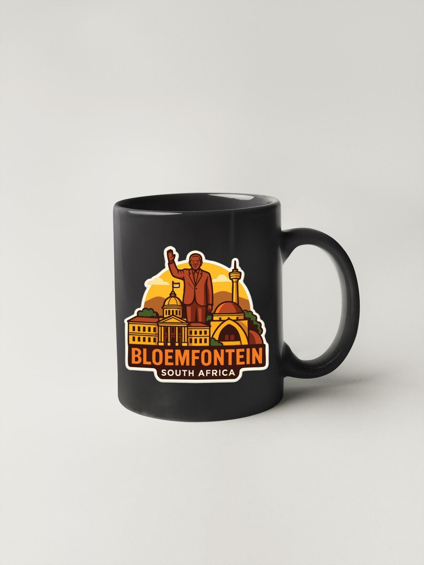 A black coffee mug with a graphic design featuring a statue and various landmarks, including a building and a tower, along with the text "BLOEMFONTEIN SOUTH AFRICA".