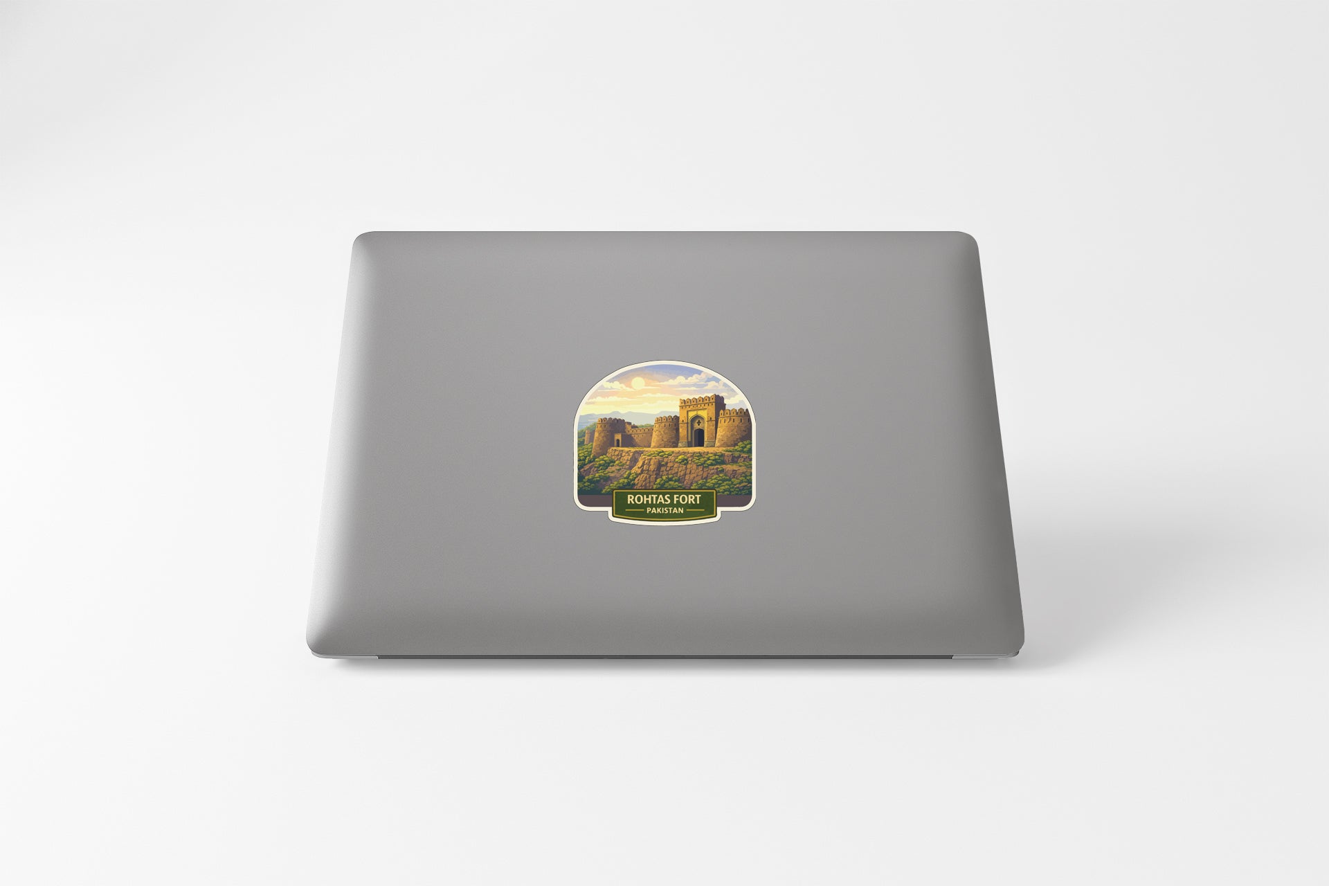 a sticker with a picture of a building, likely a castle, on the back of a laptop.