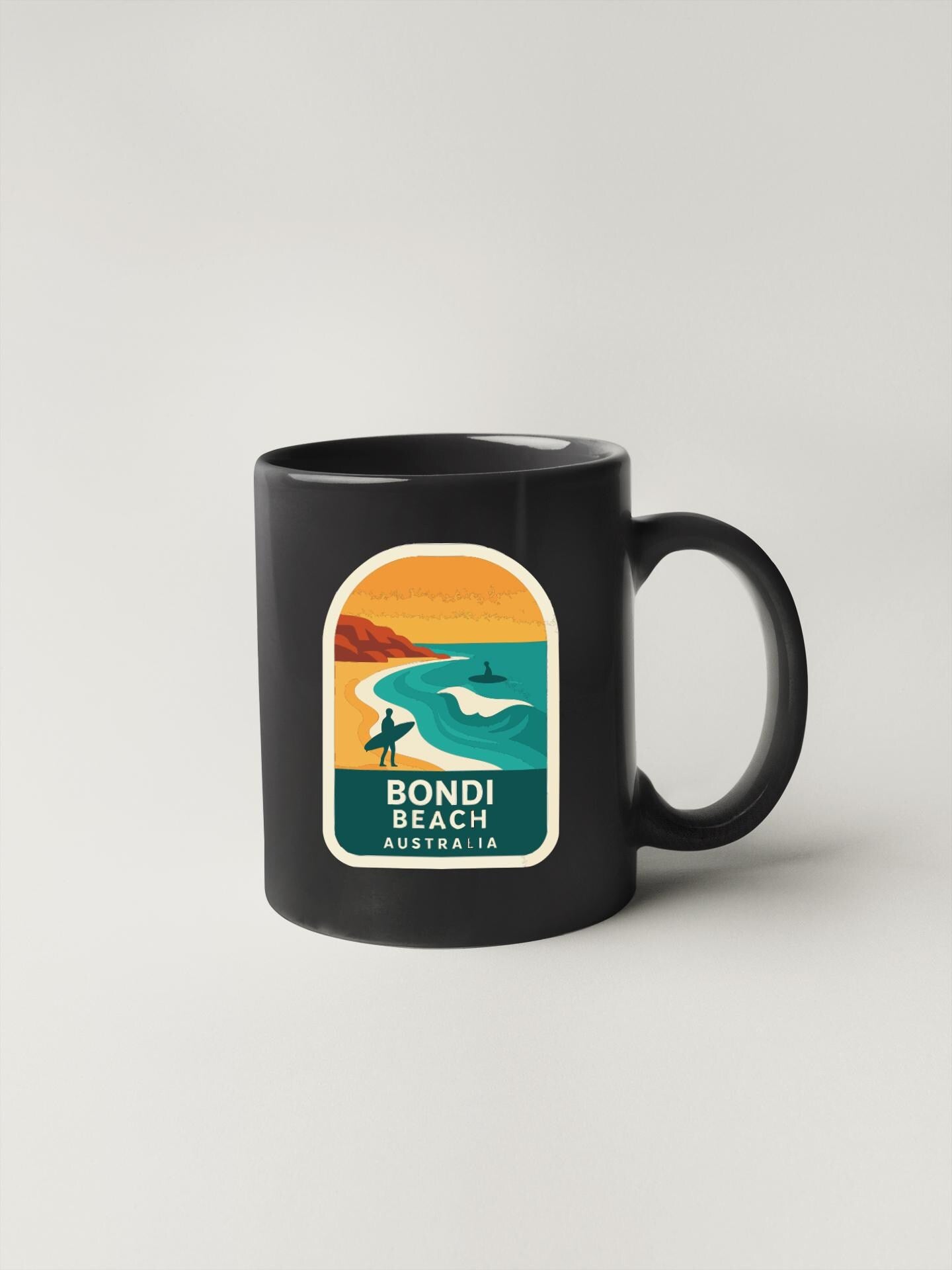 A black coffee mug with a graphic design depicting a beach scene and a surfer.