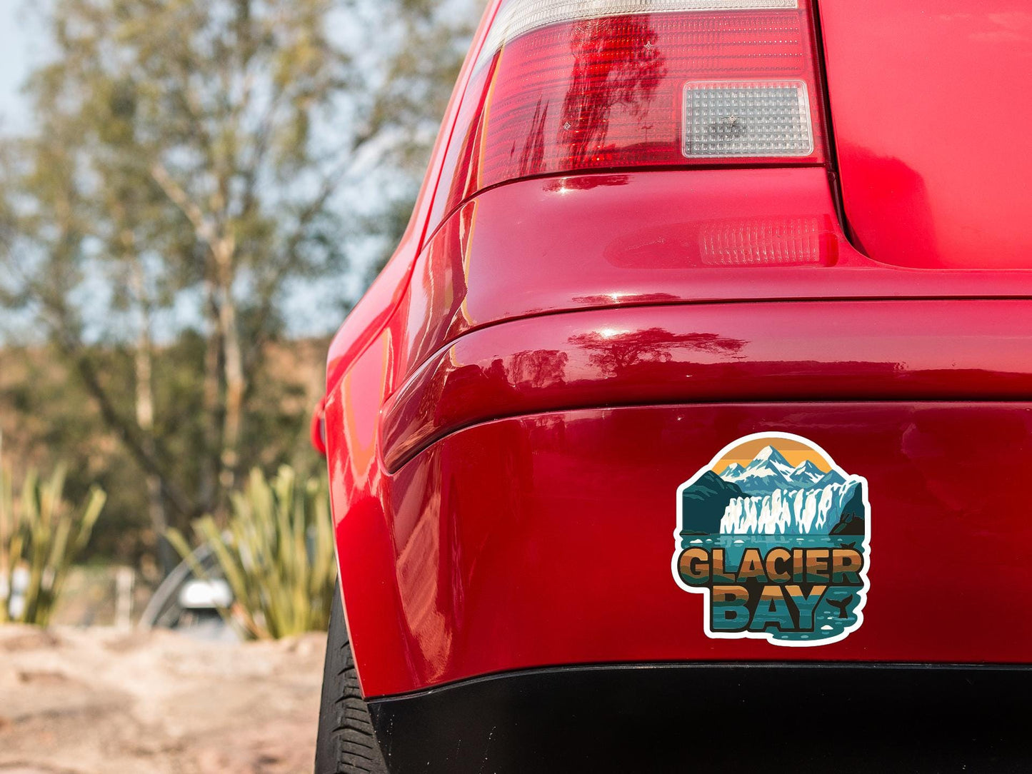 the rear end of a red car with a sticker on the bumper that says "Glacier Bay".