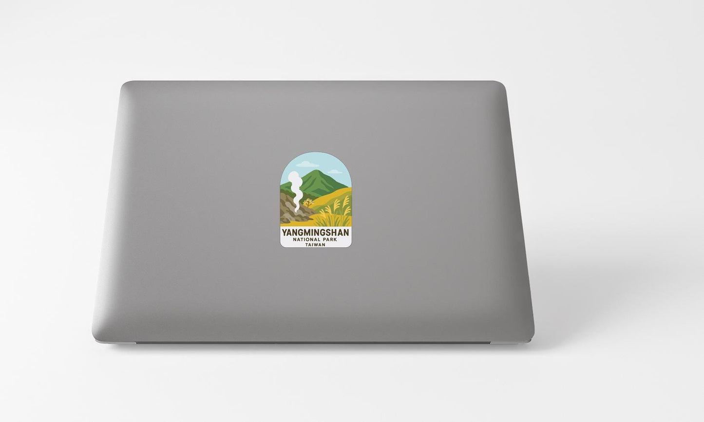 A sticker with a mountain landscape and text on the back of a laptop computer.