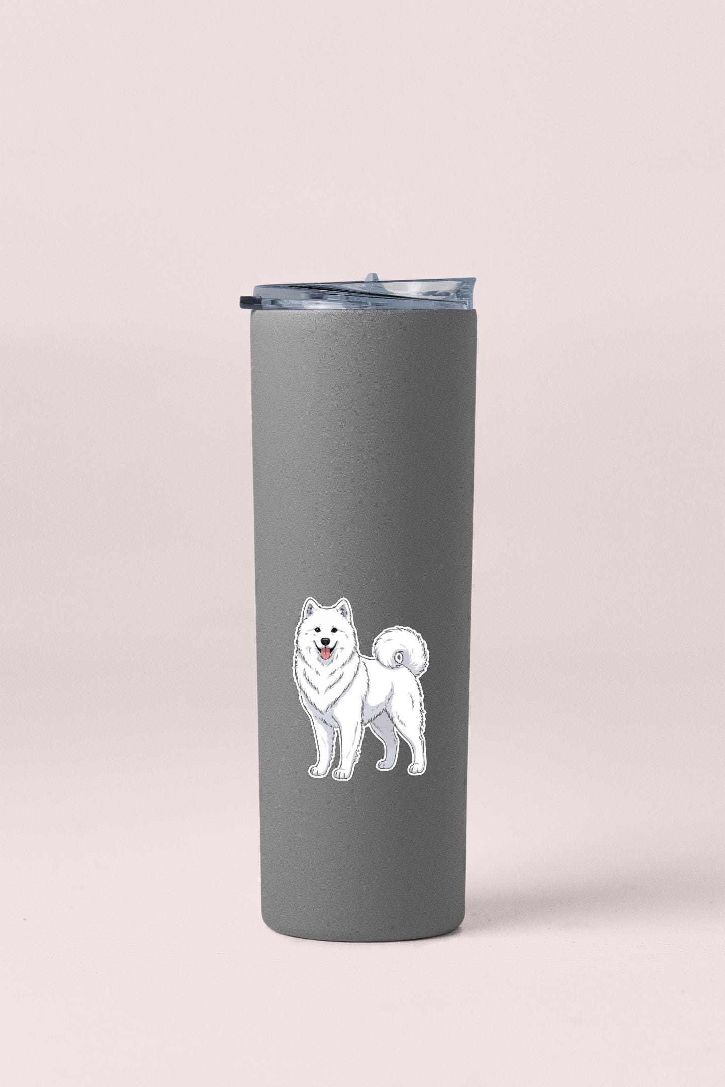 A gray insulated tumbler with a sticker of a white Samoyed dog on it.