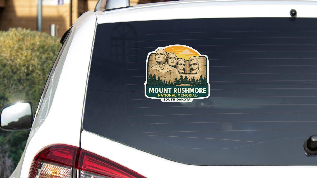 a sticker on the rear window of a vehicle that displays the iconic Mount Rushmore National Memorial in South Dakota.