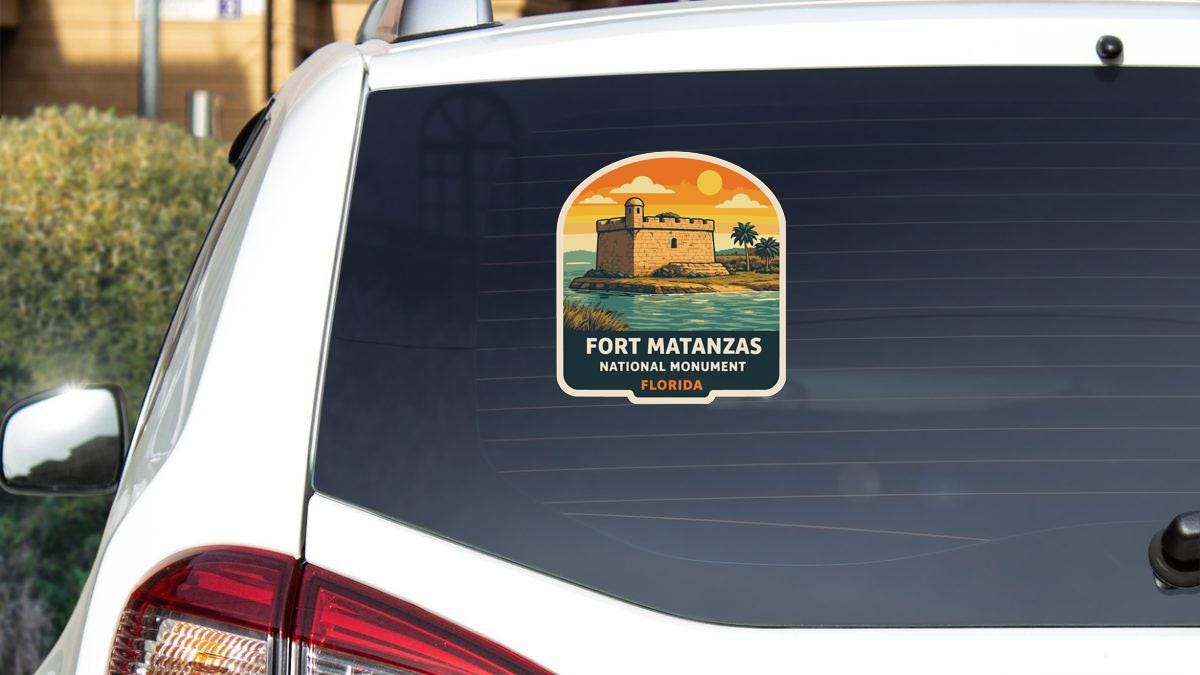 A sticker on the rear window of a car that says "PORT MATANZAS NATIONAL MONUMENT FLORIDA".