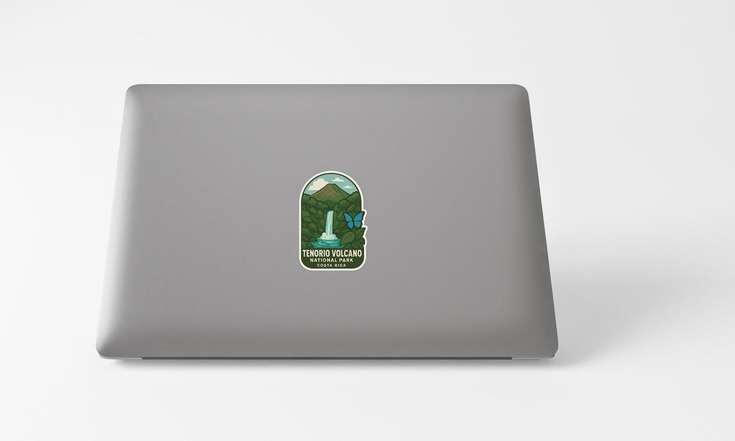 A sticker on the back of a laptop, depicting a waterfall and mountains, with the text "TENORO VOLCANO" and "TENORO VOLCANO" written on it.