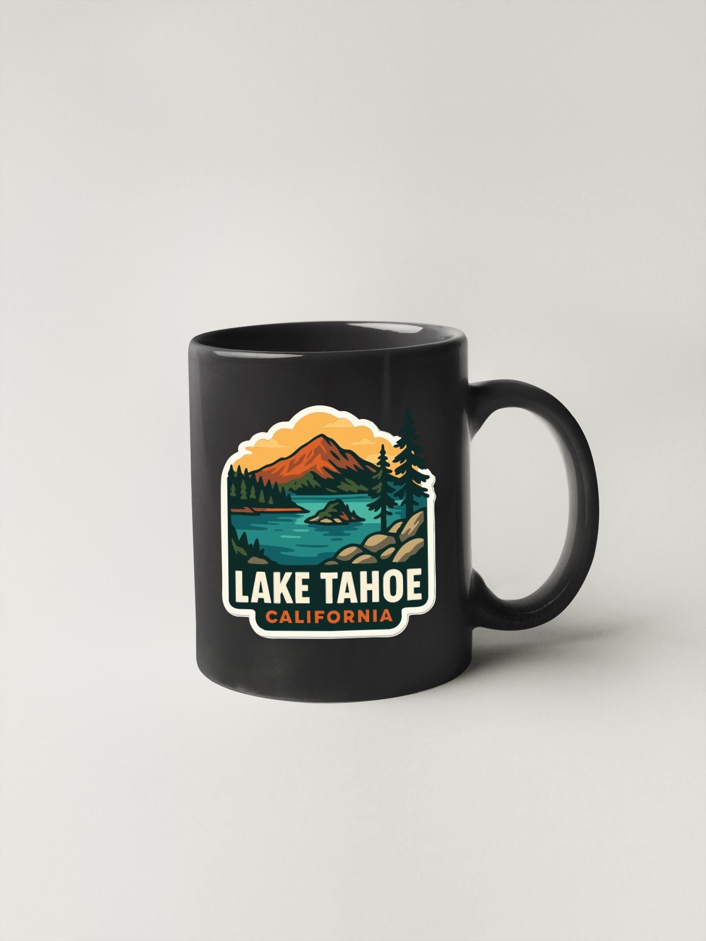 A black coffee mug with a graphic design depicting Lake Tahoe, California.