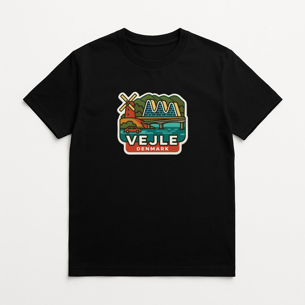 A black t-shirt with a colorful graphic depicting a windmill, mountains, and a bridge, along with the text "VEJLE DENMARK".