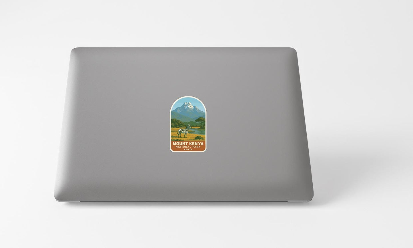 A sticker on the back of a laptop, depicting a mountain landscape with a mountain peak and a valley below.