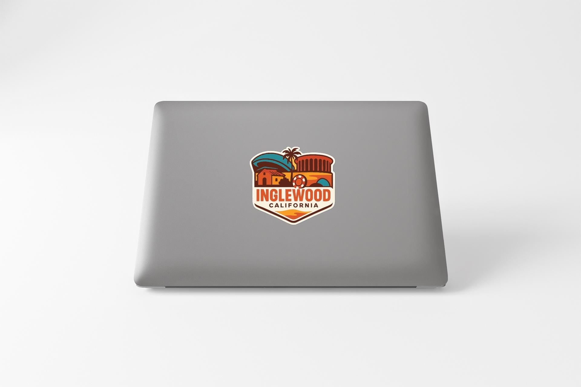 a sticker with a colorful illustration of a building and palm trees, along with the text "INGLEWOOD CALIFORNIA".
