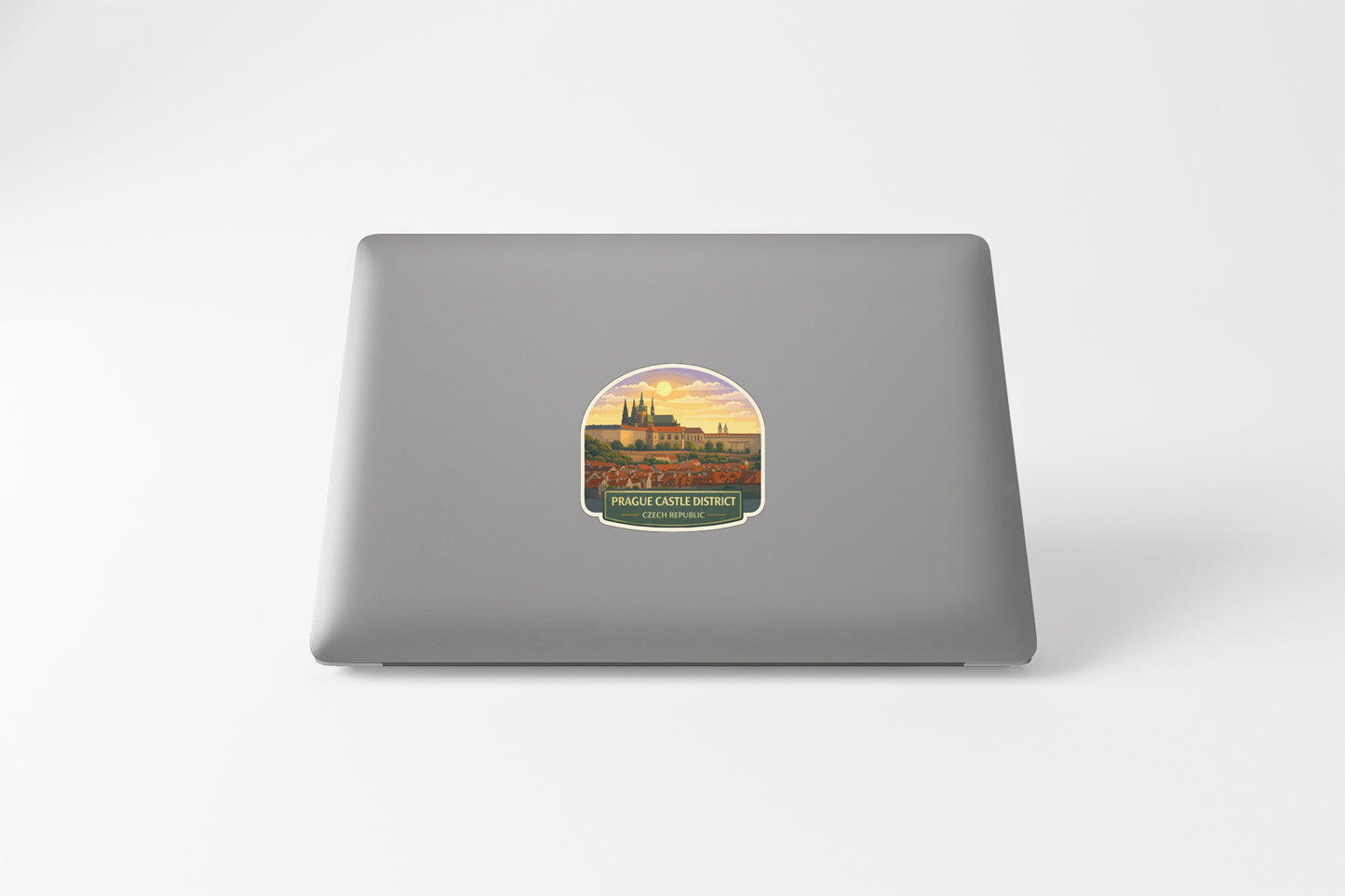 a sticker on the back of a laptop, depicting a castle or palace-like structure with a sunset or sunrise in the background.