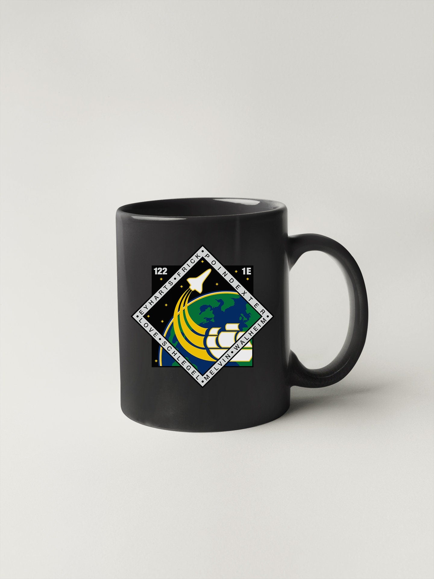a black coffee mug with a picture of a bird on it