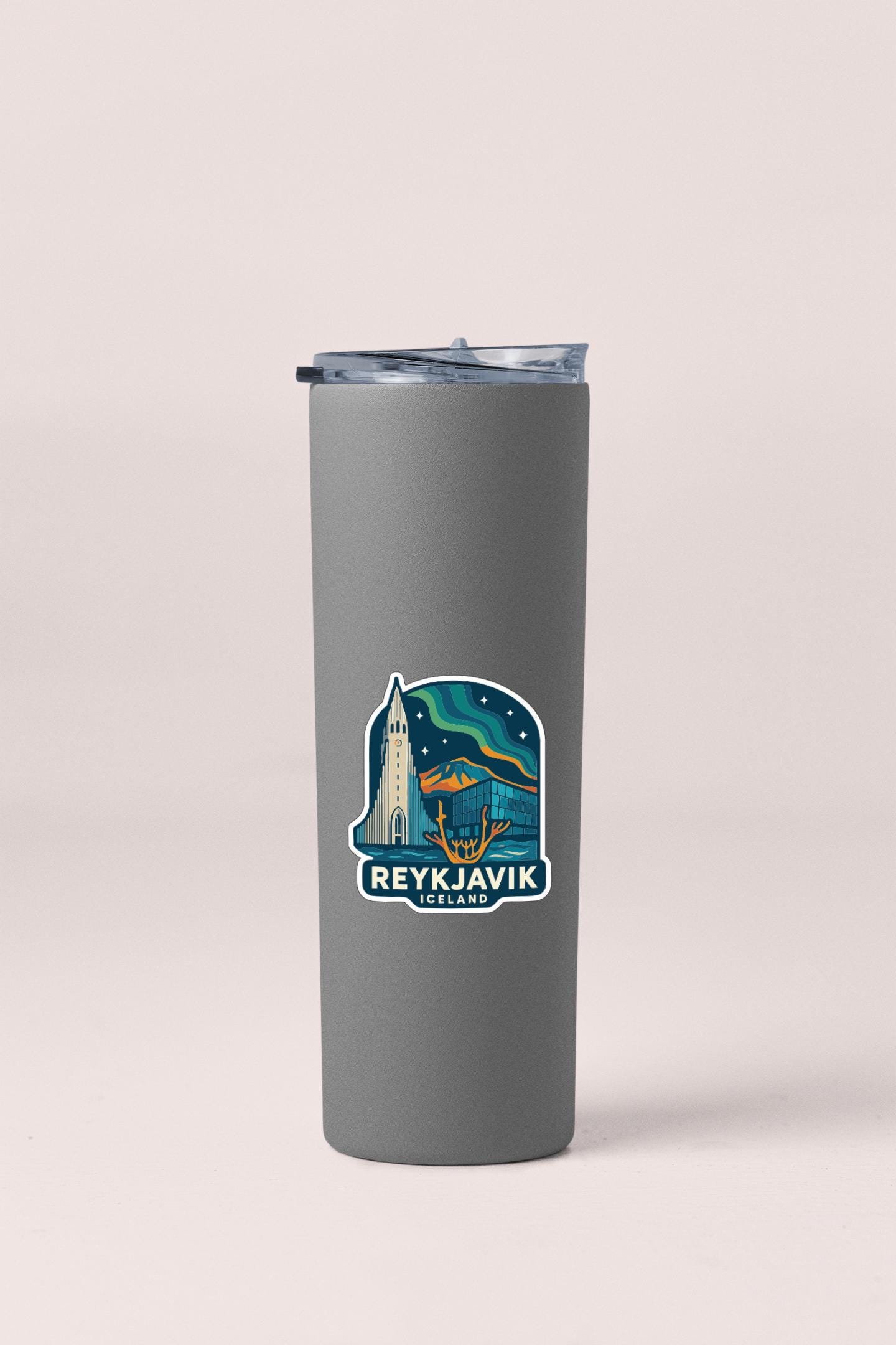 A gray insulated tumbler with a sticker depicting Reykjavik, Iceland.